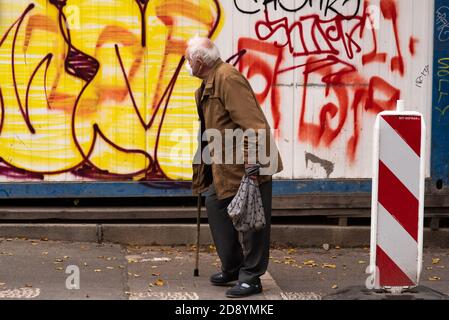 Alte Männer laufen am Morgen mit seinem Gehen Bleiben Sie in Prag 7, während Sie während der Quarantäne ein Graffiti betrachten Zeitraum aufgrund des Ausbruchs VON CO Stockfoto