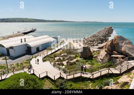 Touristen, die auf dem Holzsteg des Kaiki Walk auf Granite Island bei Victor Harbor, Südaustralien, spazieren gehen Stockfoto