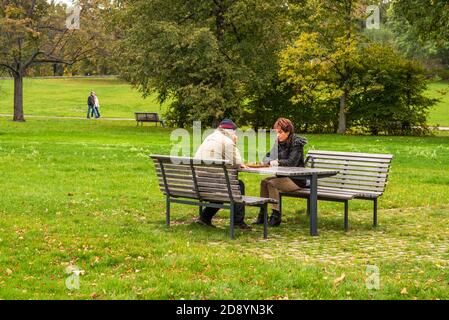 Mann und Frau sprechen und spielen Schach auf Letna Park im Herbst 2020 auf Prag 6 während der Quarantänezeit Aufgrund des Ausbruchs von COVID-19 als Winter ist Stockfoto