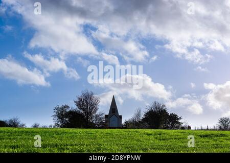 Das Monument am Farley Mount, Hampshire, England, gesehen über ein grasbewachsenes Feld, das von Sonnenlicht beleuchtet wird. Stockfoto