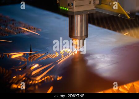 Automatische cnc-Laserschneidemaschine, die mit Blech mit Funken im Werk, Werk arbeitet. Metallbearbeitung, Industrie, Bearbeitung, Technologie Stockfoto