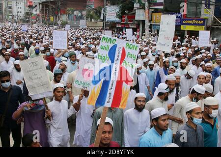 Während einer Anti-Frankreich-Demonstration in Dhaka zeigen Demonstranten Plakate.Tausende von Muslimen protestieren mit dem Aufruf zum Boykott französischer Produkte und verurteilen den französischen Präsidenten Emmanuel Macron für seine Äußerungen, die Karikaturen des Propheten Mohammed nicht aufzugeben. Macrons Bemerkungen kamen als Reaktion auf die Enthauptung eines Lehrers, Samuel Paty, außerhalb seiner Schule in einem Vorort außerhalb von Paris Anfang dieses Monats, nachdem er Karikaturen des Propheten Mohammed während einer Klasse gezeigt hatte, die er in der freien Meinungsäußerung leitete. Stockfoto