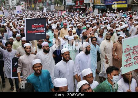 Während einer Anti-Frankreich-Demonstration in Dhaka zeigen Demonstranten Plakate.Tausende von Muslimen protestieren mit dem Aufruf zum Boykott französischer Produkte und verurteilen den französischen Präsidenten Emmanuel Macron für seine Äußerungen, die Karikaturen des Propheten Mohammed nicht aufzugeben. Macrons Bemerkungen kamen als Reaktion auf die Enthauptung eines Lehrers, Samuel Paty, außerhalb seiner Schule in einem Vorort außerhalb von Paris Anfang dieses Monats, nachdem er Karikaturen des Propheten Mohammed während einer Klasse gezeigt hatte, die er in der freien Meinungsäußerung leitete. Stockfoto