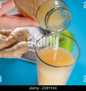 Obst Kürbis Apfel Karotte Ingwer auf farbigem Hintergrund Hände Saft Lecker Stockfoto