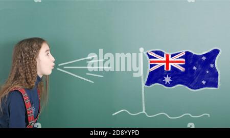 Vorpubertär Mädchen weht auf der Schultafel gezeichnet auf der Tafel Australien Flagge. Hochauflösendes Foto. Volle Schärfentiefe. Stockfoto