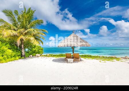 Liegen und Sonnenschirm am Strand mit Schatten von Palmen. Liegen und Sonnenschirm an einem tropischen Strand, Luxus Sommerurlaub, Paare Urlaub, idyllische Aussicht Stockfoto