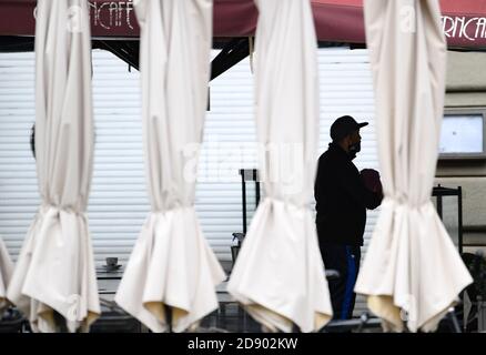 02. November 2020, Hessen, Frankfurt/Main: Ein Mitarbeiter des geschlossenen Operncafés reinigt eine Heizsäule der Außengastronomie. In ganz Deutschland hat eine vierwöchige Teilsperre begonnen, um die Ausbreitung des Corona-Virus zu verlangsamen. Foto: Arne Dedert/dpa Stockfoto