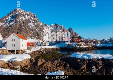 Alte traditionelle Fischerhütte namens Rorbu in der Nähe von Svolvaer auf der Lofoten Inseln in Norwegen im Winter mit Schnee auf klar Tag mit blauem Himmel Stockfoto