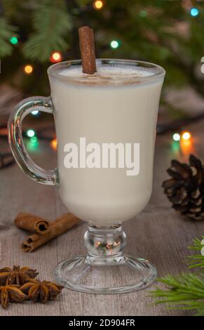 Cocktail in einem Glas-Becher mit Griff. Selektiver Fokus. Weihnachtlicher Eiernusscocktail mit geriebener Muskatnuss und Zimt. Stockfoto