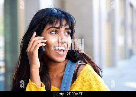 Porträt der kühlen jungen indischen Frau im Gespräch auf Handy Draußen in der Stadt Stockfoto