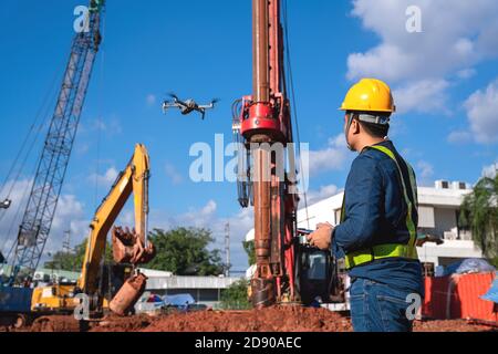 Drohneninspektion neue Baustelle. Betreiber, der die neue Baustellenkontrolle durch Bauingenieur inspiziert Stockfoto