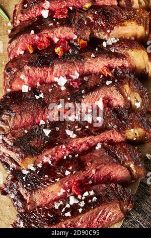 Nahaufnahme von geschnittenem gegrilltem Medium Rare Ribeye Steak mit Salzkristalle Stockfoto