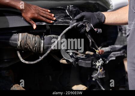 Zwei freundliche professionelle Auto-Mechaniker während der Arbeit, sind sie erfolgreich Reparatur Auto, lösen Probleme zusammen Stockfoto
