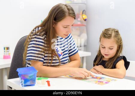 Kinder logopädische Therapie Konzept. Vorschulkind üben die richtige Aussprache mit einem weiblichen Logopädin. Stockfoto