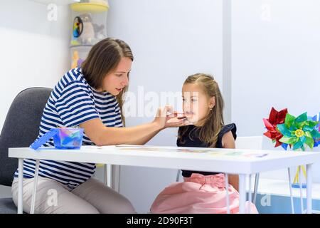 Kinder logopädische Therapie Konzept. Vorschulkind üben die richtige Aussprache mit einem weiblichen Logopädin. Stockfoto