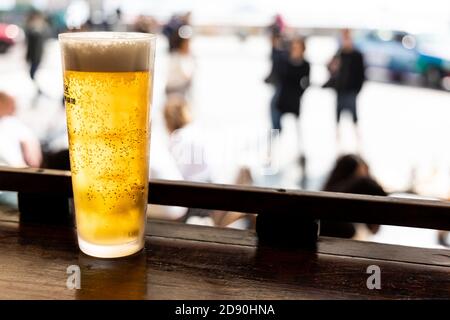 Ein Glas goldenes kaltes Bier auf der Theke gegenüber der Straße Stockfoto