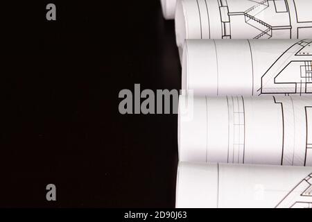Architekturprojekt, Zeichnungen auf dunklem Hintergrund. Rollen von Projektzeichnungen Stockfoto