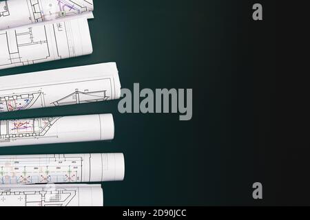Architekturprojekt, Zeichnungen auf dunklem Hintergrund. Rollen von Projektzeichnungen Stockfoto