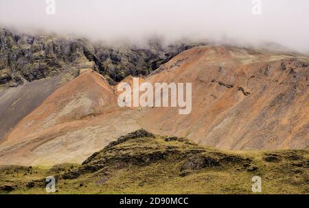 Niedrige Wolken hängen über der abgelegenen Felsengebirgslandschaft Südislands. Stockfoto