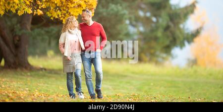 Partner bei einem Spaziergang in der Natur an einem sonnigen Herbsttag. Stockfoto