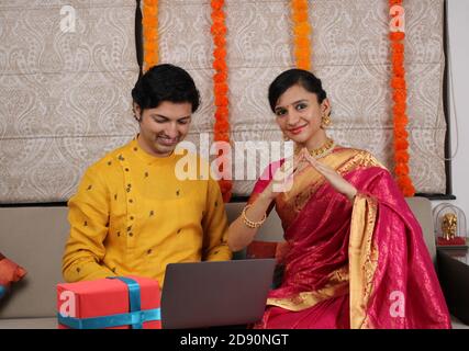 Indische junge Familie Paar Wahl neues Zuhause online, suchen Immobilien zu kaufen oder zu mieten, Haus zum Verkauf auf dem Bildschirm des Computers. Stockfoto