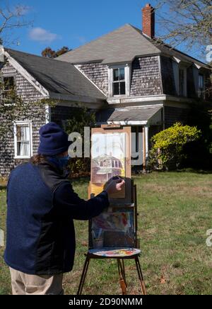 Ein Künstler bei der Arbeit Malerei der historischen Fuller Farmhouse in Barnstable, Massachusetts, USA an einem späten Herbstmorgen Stockfoto