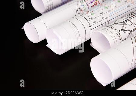 Architekturprojekt, Zeichnungen auf dunklem Hintergrund. Rollen von Projektzeichnungen Stockfoto