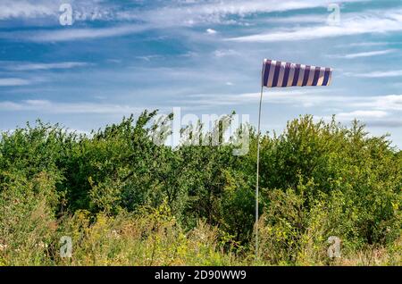 Blaue Wetterfahne Wetterfahne im kleinen Flughafen auf einem Hintergrund von grünen Bäumen Stockfoto