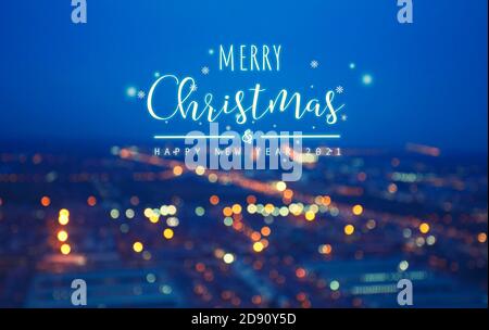 Worttext fröhliche Weihnachten auf weißem Hintergrund und verschwommen Foto Bokeh von Stadtbild Stockfoto
