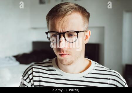 Müde nachdenkliche Mann tief zu Hause denken. Winterdepression. Saisonale affektive Störung, Angst, psychische Gesundheit, Psychologie. Unglücklicher Mann hat Familie Stockfoto