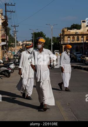 Jaisalmer, Rajasthan / Indien - november 02 2020 : drei alte Senioren Männer tragen Maske zu Fuß in der Mitte der Straße Stockfoto