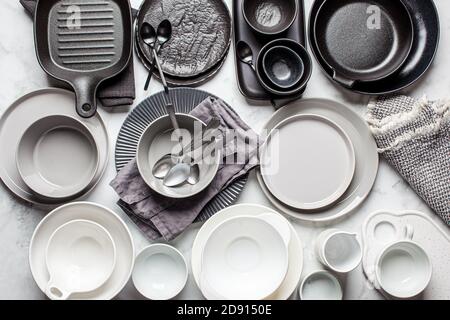 Flache Verlegung von leeren sauberen Tellern und Schüsseln auf weißem Marmorhintergrund. Stockfoto