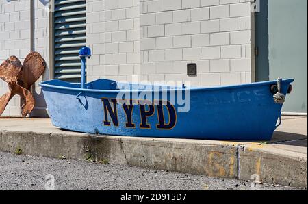 Dieses alte Dingy sitzt vor dem NYPD Harbor Unit Hauptquartier in Sunset Park, Brooklyn NY Stockfoto