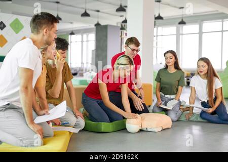 Junge Frau Frage stellen, wie man das Leben von Lehrer zu retten, Praxis auf Dummy Stockfoto
