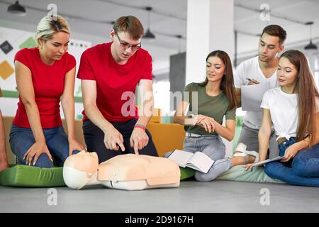 kaukasische Menschen üben eine Übung der Reanimation während des Unterrichts, helfen Verletzten, erste Hilfe und Medizin Konzept Stockfoto