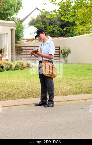 Johannesburg, Südafrika - 11. September 2010: Post Mailman Hand liefert Post in einem wohlhabenden Vorort Nachbarschaft Stockfoto