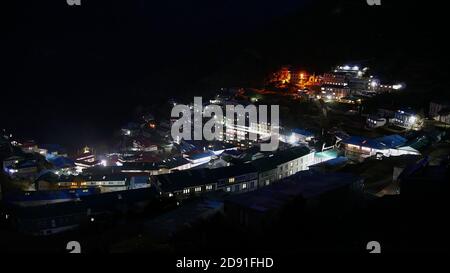 Panorama-Nachtansicht über das Dorf Namche Bazar (3,440 m), Zentrum der Khumbu-Region im Himalaya, Nepal mit beleuchteten Häusern und Lodges. Stockfoto