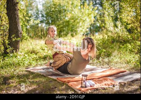 Massageexperte wendet ihre Massagefähigkeiten auf ihren Klienten auf dem Gras an. Stockfoto