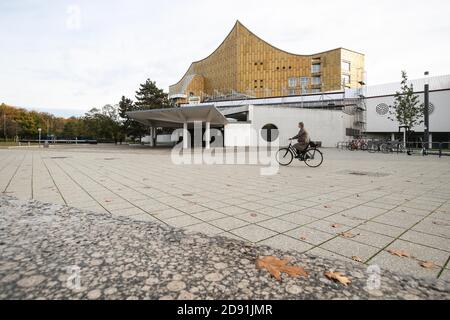 Berlin, Deutschland. November 2020. Ein Radfahrer kommt am 2. November 2020 an der geschlossenen Berliner Philharmonie in Berlin vorbei. Bund und Länder haben sich mit Wirkung zum 2. November darauf geeinigt, weitreichende Kontaktbeschränkungen im Alltag einzuführen, um den steilen Anstieg von COVID-19-Infektionen einzudämmen, berichtete die Deutsche Presseagentur (dpa) am Mittwoch. Quelle: Shan Yuqi/Xinhua/Alamy Live News Stockfoto