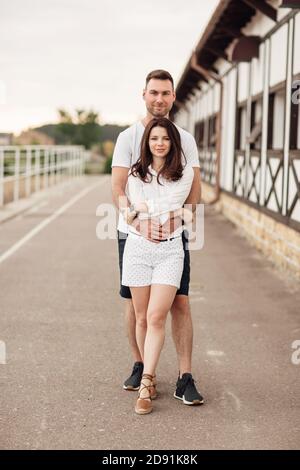 Glückliche junge Mann und Frau mit Spaß im Freien an einem warmen Sommertag. Paar umarmt in der Nähe Pferd rancho Stockfoto