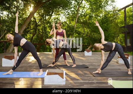 Frauen tun Übung mit Lehrer, Gruppe Yoga Stockfoto