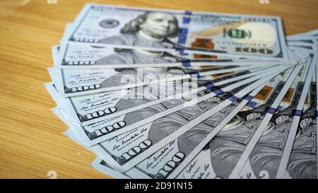 Ein Stapel von US-Dollar auf Holzbrettern verstreut. Stockfoto