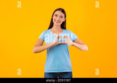 Frau macht Herzform mit ihren Händen Stockfoto