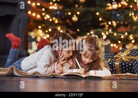 Zwei kleine Mädchen haben Spaß in weihnachten dekoriert Zimmer mit Geschenkschachteln Stockfoto