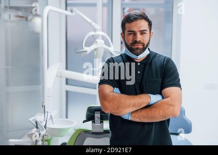 Porträt des Zahnarztes in Handschuhen, die im Innenbereich stehen Klinik Stockfoto