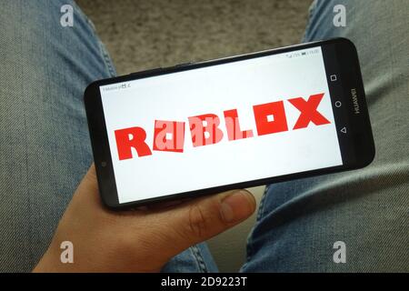 Mann hält Smartphone mit Roblox Plattform-Logo Stockfoto