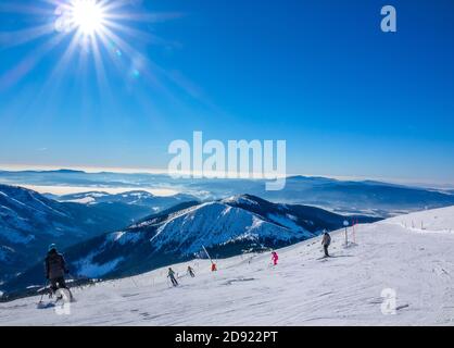 Skigebiet Jasna im Winter Slowakei. Panoramablick von der Spitze der schneebedeckten Berge und Skipiste mit Skifahrern Stockfoto