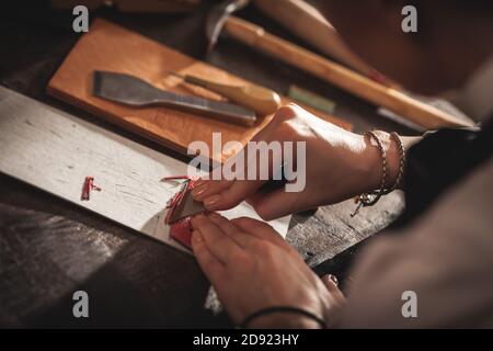 Lederhandtasche Handwerker bei der Arbeit in einer Vintage-Werkstatt. Konzept für kleine Unternehmen Stockfoto