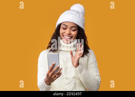 Glückliche schwarze Frau macht Videoanruf mit Handy Stockfoto