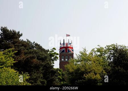 Faringdon Folly, direkt über der Baumgrenze gesehen, mit der Spitze in die Unionsflagge gehüllt, um Prinz William und Kate's Hochzeit zu feiern 29 April 2011. Stockfoto